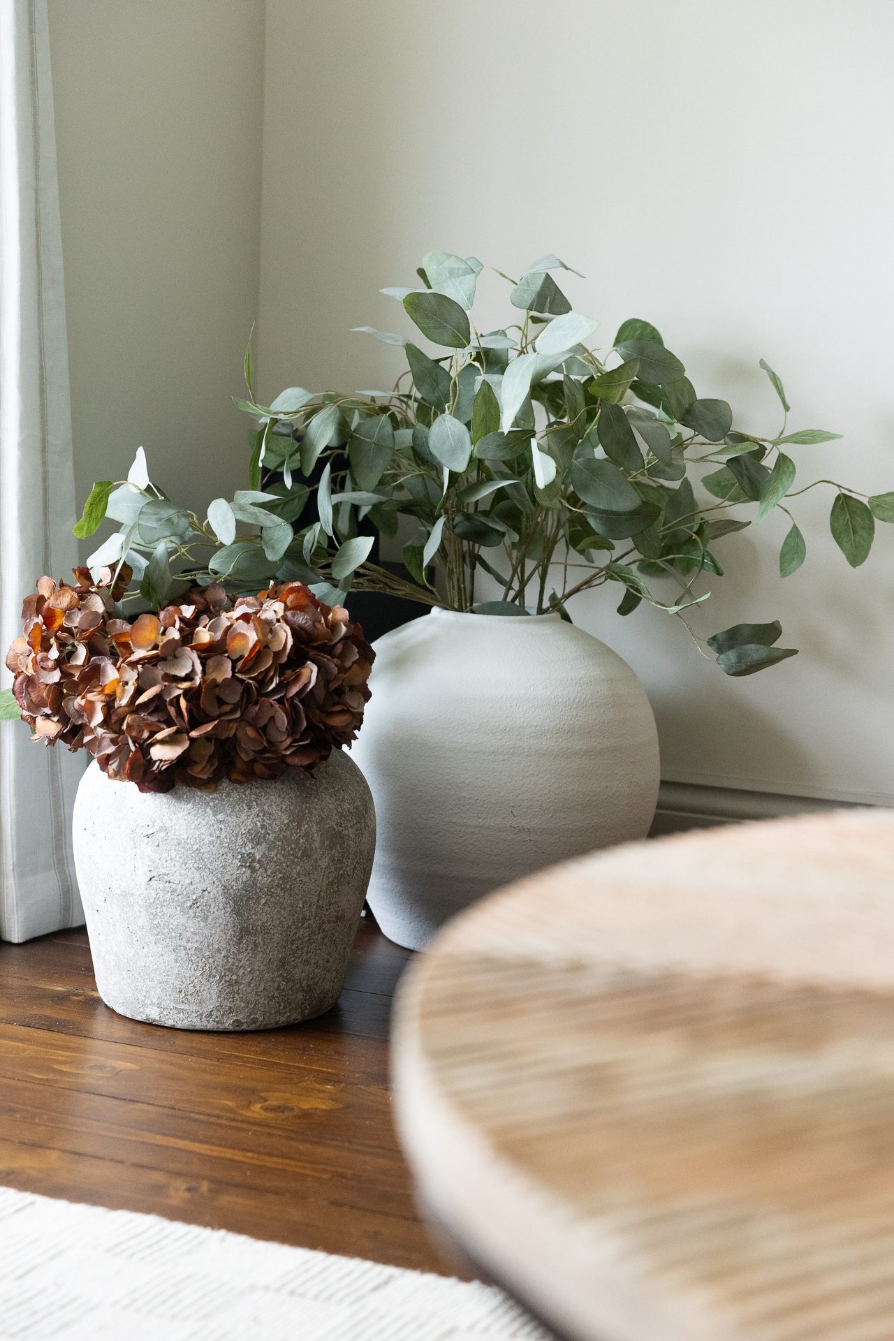 Dried hydrangea and fresh eucalyptus held in a stone pot on the Bamburgh coffee table