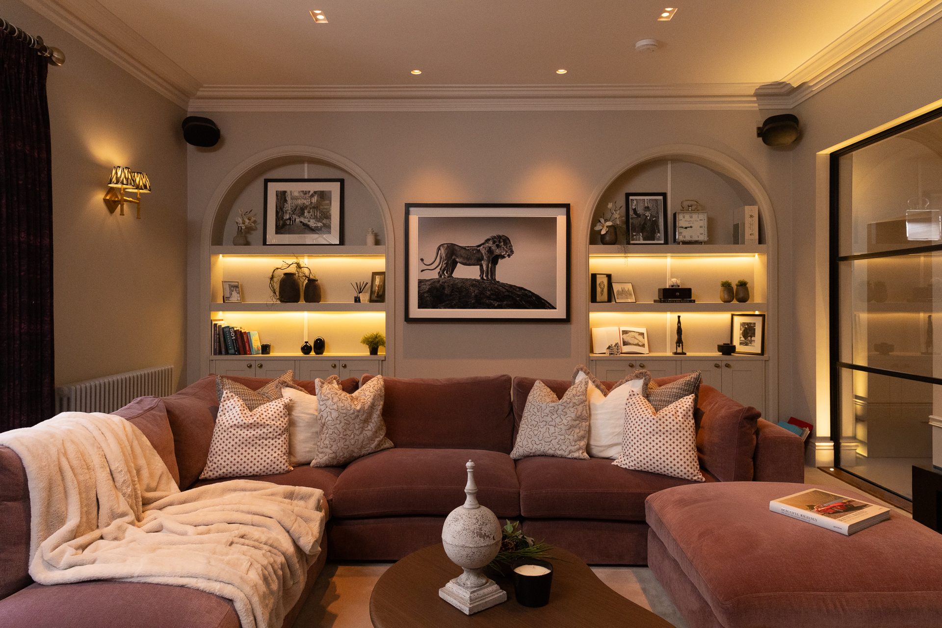 The snug at Elmfield Road with arched niche shelving and warm lighting