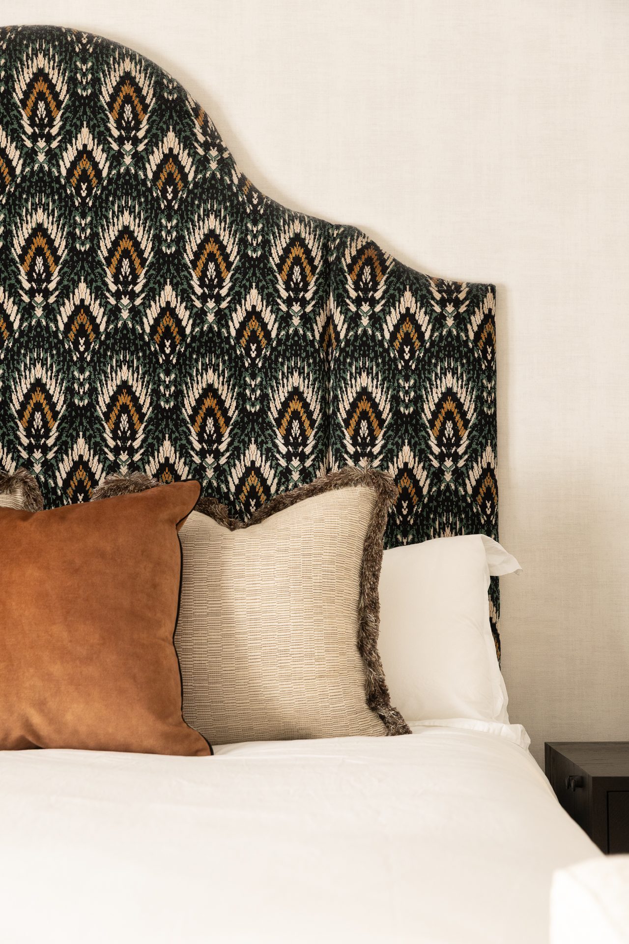 Close detail of the ikat headboard, patterned cushions and bedside styling