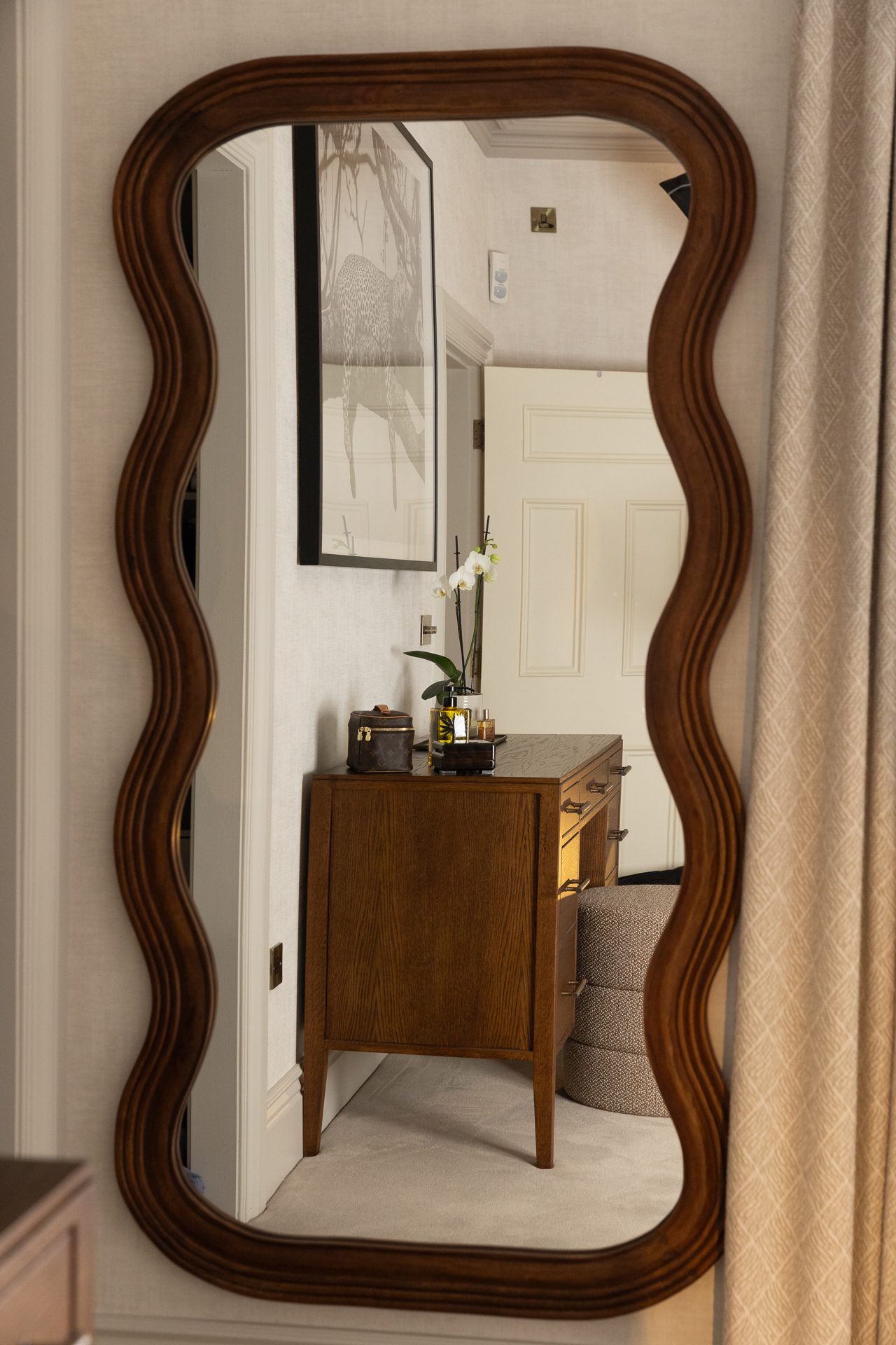 A dressing corner with a framed mirror in the guest bedroom