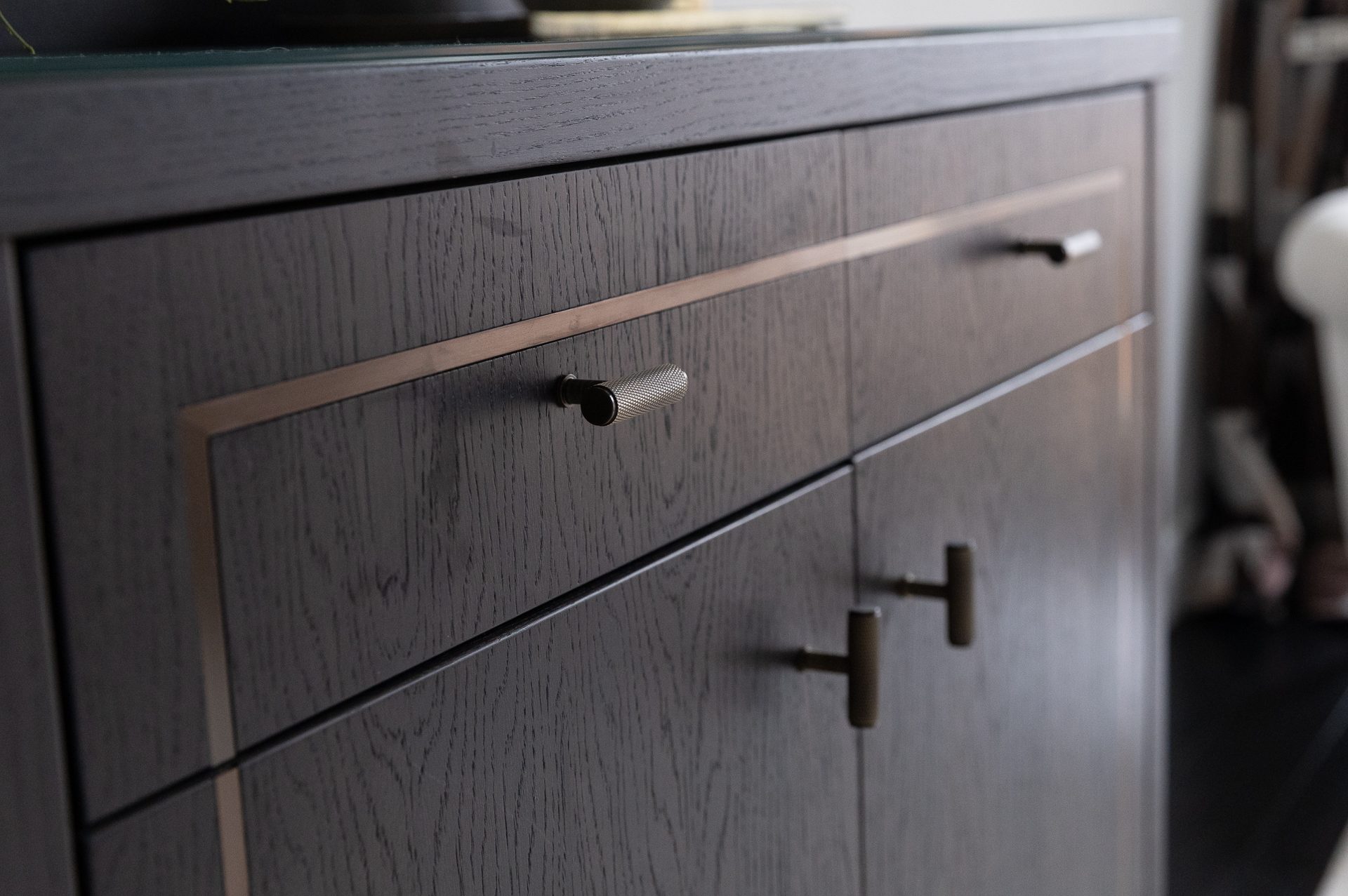 Sycamore dressing room, dark cabinetry with brass accents and island counter