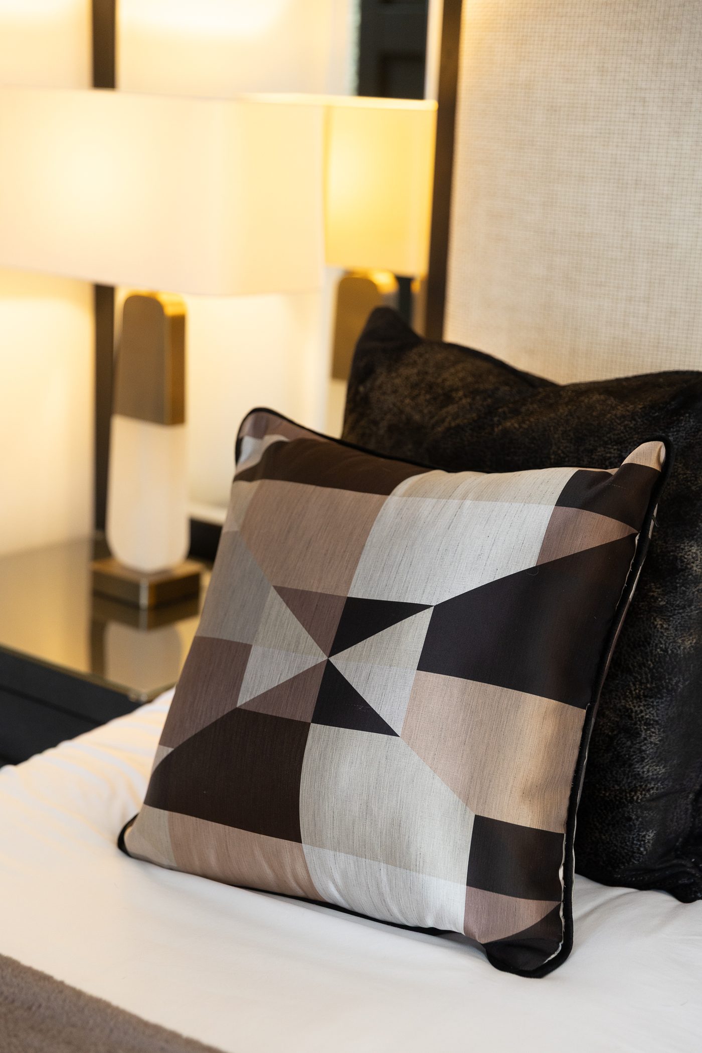 A geometric patterned cushion detail, reflecting the contemporary pattern work Harlequin brings into a scheme